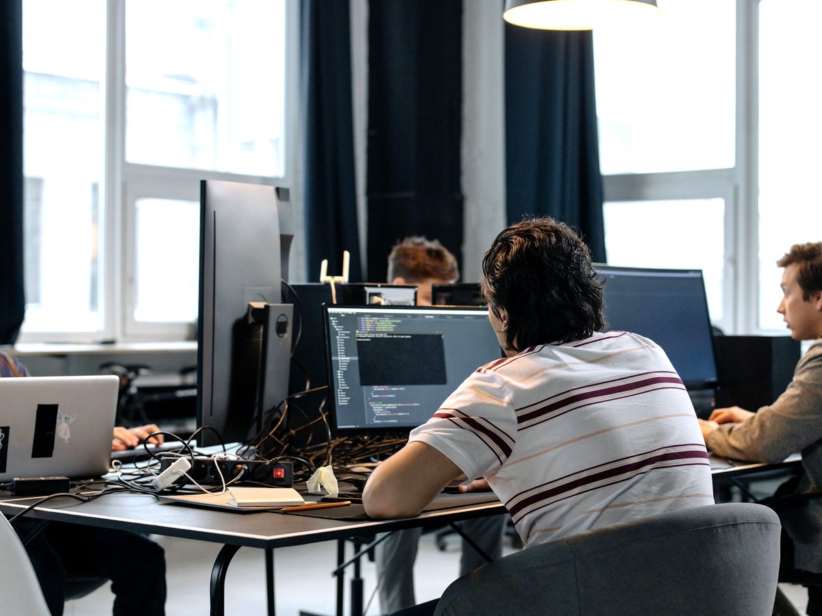A software team collaborating at their workstations
